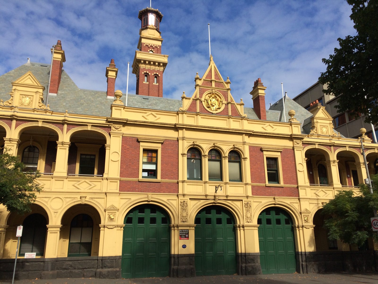 The Eastern Hill fire station on Victoria Parade: gold and red brick, a tall tower and three green engine-bay doors